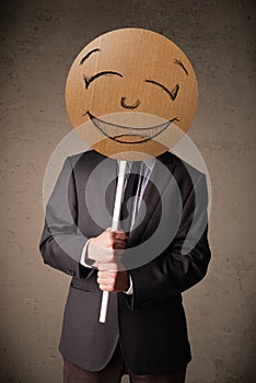 Businessman holding a smiley face board