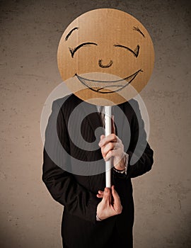 Businessman holding a smiley face board