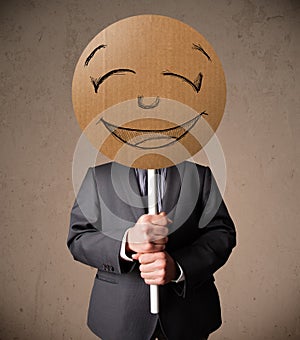 Businessman holding a smiley face board