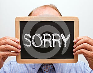 Businessman holding sorry sign
