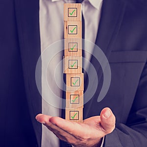 Businessman holding a stack of checked boxes