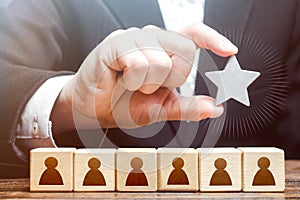 A businessman is holding a star over the team. Awarding. High appreciation and reward for work. Optimal team size, efficiency and photo