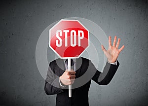 Businessman holding a stop sign