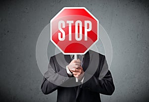 Businessman holding a stop sign