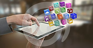 Businessman holding tablet with apps icons in office