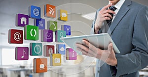 Businessman holding tablet with apps icons in workshop factory office