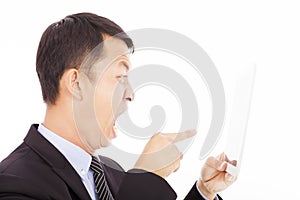 Businessman holding a tablet or ipad and screaming to point it