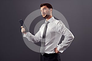 Businessman holding tablet pc and looking up