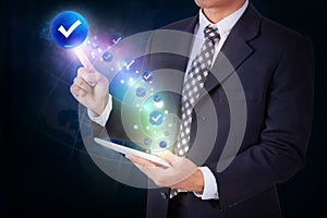 Businessman holding tablet with pressing check mark icon button.