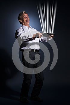 Businessman holding a tablet radiating light photo