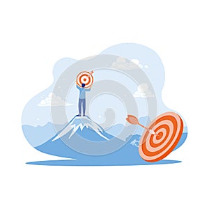 Businessman holding target board on a mountain top. Efforts to achieve goals. Marketing concept.