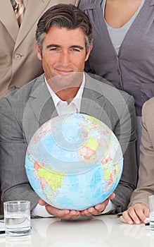 Businessman holding a terrestrial globe