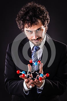Businessman holding a tnt atomic structure