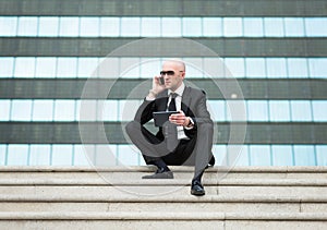 Businessman is holding touch pad in hands and communicating via