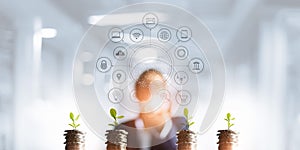 Businessman holding a tree sprout growing on coins, abstract growth investing. Finance and icon customer, banking network
