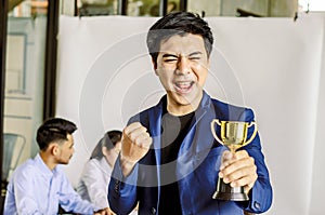 Businessman holding trophy award for success in business,