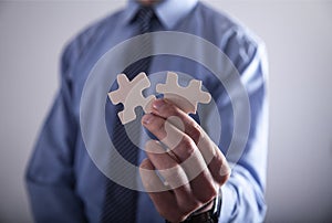 Businessman holding two jigsaw puzzle piece. Success and Business