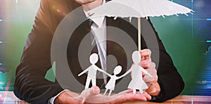 Composite image of businessman holding umbrella and paper family