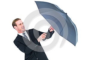 Businessman holding umbrella to protect himself