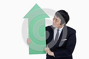 Businessman holding up an arrow, pointing upwards