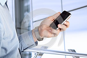 Businessman holding and using the mobile phone