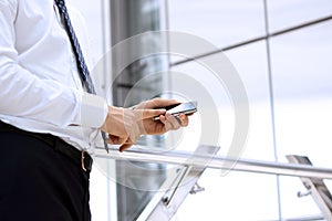 Businessman holding and using the mobile smart phone in the office