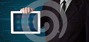 Businessman holding a white modern tablet with blurry apps