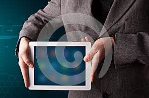 Businessman holding a white modern tablet with blurry apps