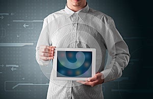 Businessman holding a white modern tablet with blurry apps