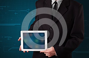 Businessman holding a white modern tablet with blurry apps