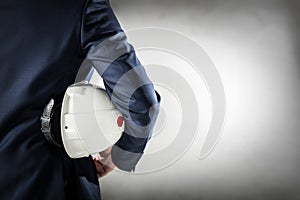 Businessman holding white safety helmet.