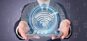 Businessman holding Wifi icon with stats and binary code 3d rendering
