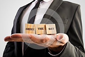Businessman holding wooden cubes in the palm of his hand with th