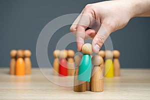 Businessman holding a wooden man in his hand. The concept of market segmentation. Target audience, customer care. Market group of