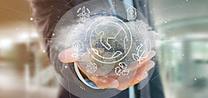 Businessman holding a World globe surronding by ecology icons an photo