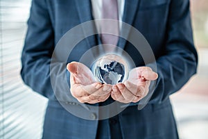 Businessman is holding world sphere. concept of beeing connected and ruling the world, global domination.