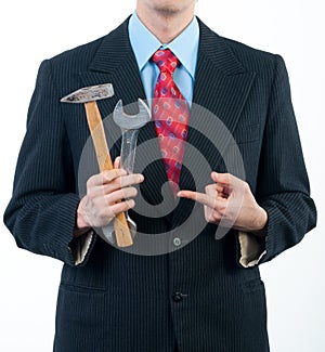 Businessman holding wrench and hammer