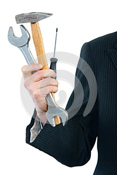 Businessman holding wrench, hammer and screwdriver