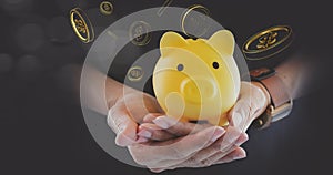 Businessman holding yellow piggy bank with golden coins, financial concept, money growth and saving money. Investment Balances,