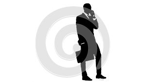 Businessman holds a briefcase and speaks on the phone. White background. Silhouette