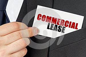Businessman holds a card with the text - COMMERCIAL LEASE photo