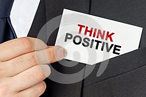 Businessman holds a card with the text - THINK POSITIVE