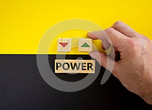 Businessman holds a cubes with up icon. Wooden cubes with word `power`. Beautiful yellow and black background. Copy space.