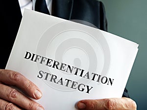 Businessman holds differentiation strategy. photo