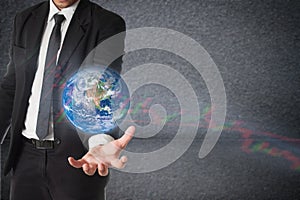 Businessman holds Earth in a hand with stock graph. Concept of r