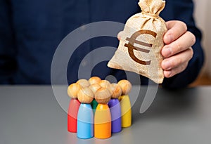 A businessman holds a euro money bag near a group of people figurines. Preferential loans for entrepreneurs and businesses.