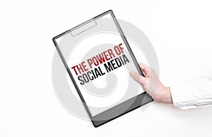 A businessman holds a folder with paper sheet with the text THE POWER OF SOCIAL MEDIA. Business concept