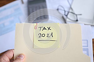 Businessman holds in hands folder with documents for filing tax return