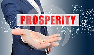 A businessman holds his hand, palm up, above the palm the inscription - PROSPERITY