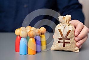 A businessman holds a japanese yen money bag near a group of people figurines.